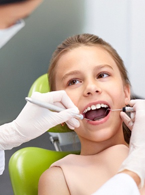 Kids dentist completing a checkup on a young patient.