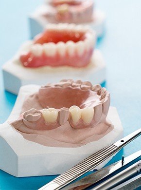 partial dentures sitting next to dental tools